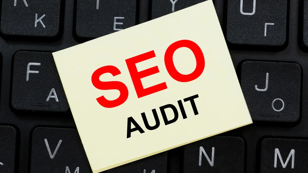 Sticky note with 'SEO Audit' on a keyboard, highlighting the importance of technical SEO audit services.